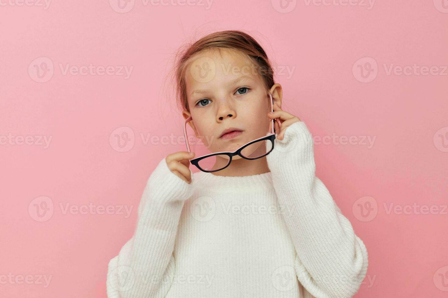 Portrait of happy smiling child girl in a white sweater and glasses isolated background photo