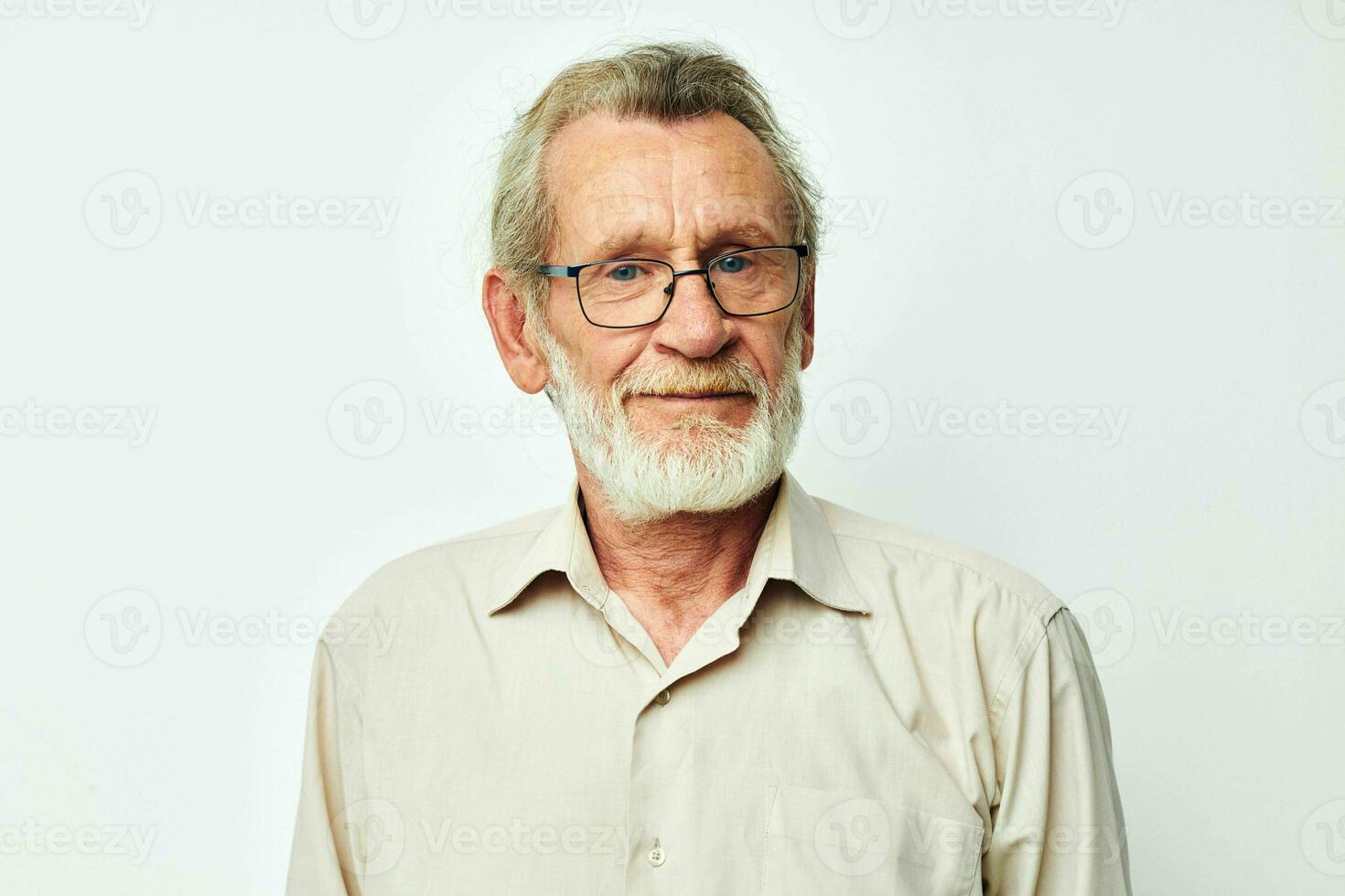 Photo of retired old man with a gray beard in a shirt and glasses light background