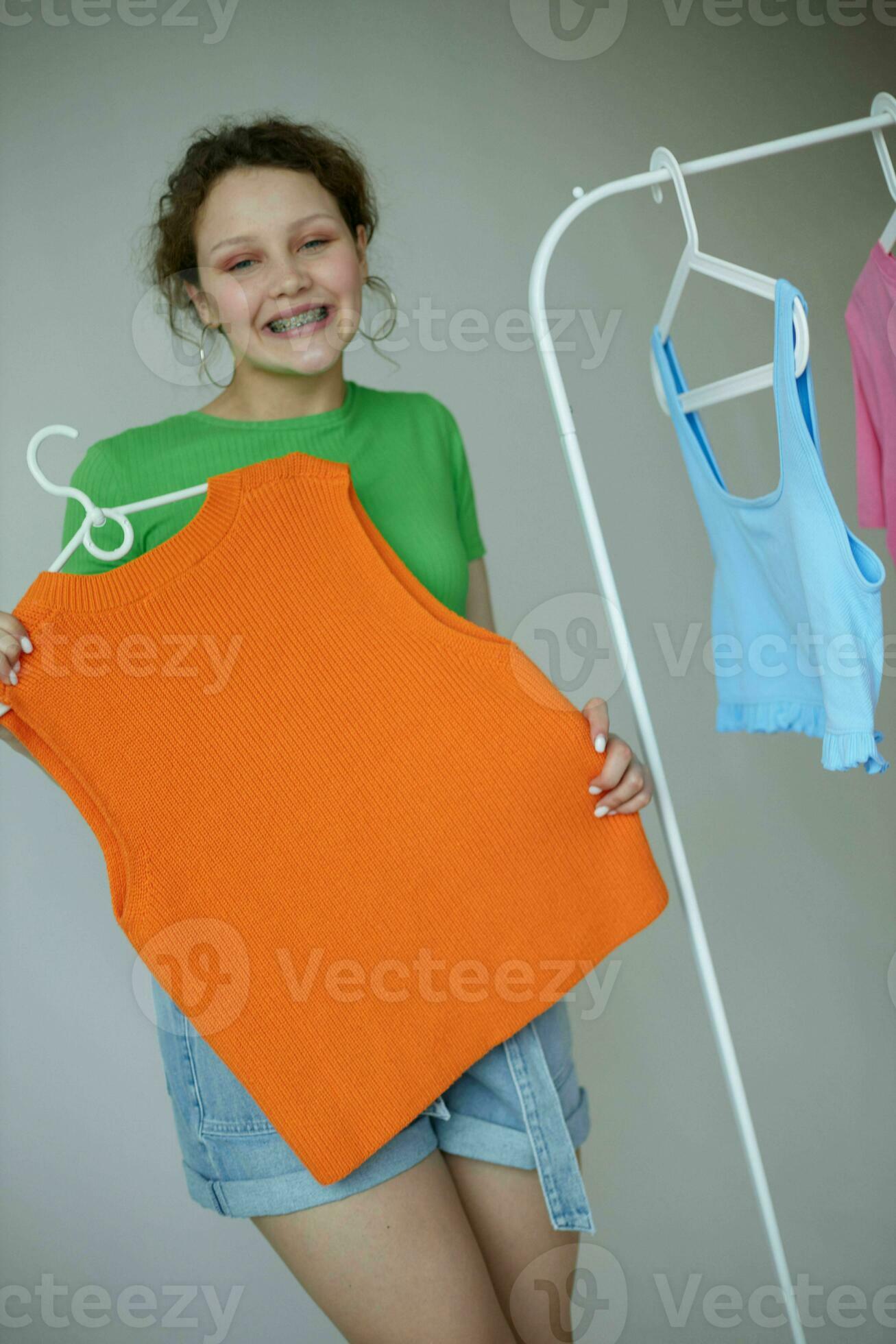 pretty girl trying on clothes wardrobe Youth style light background