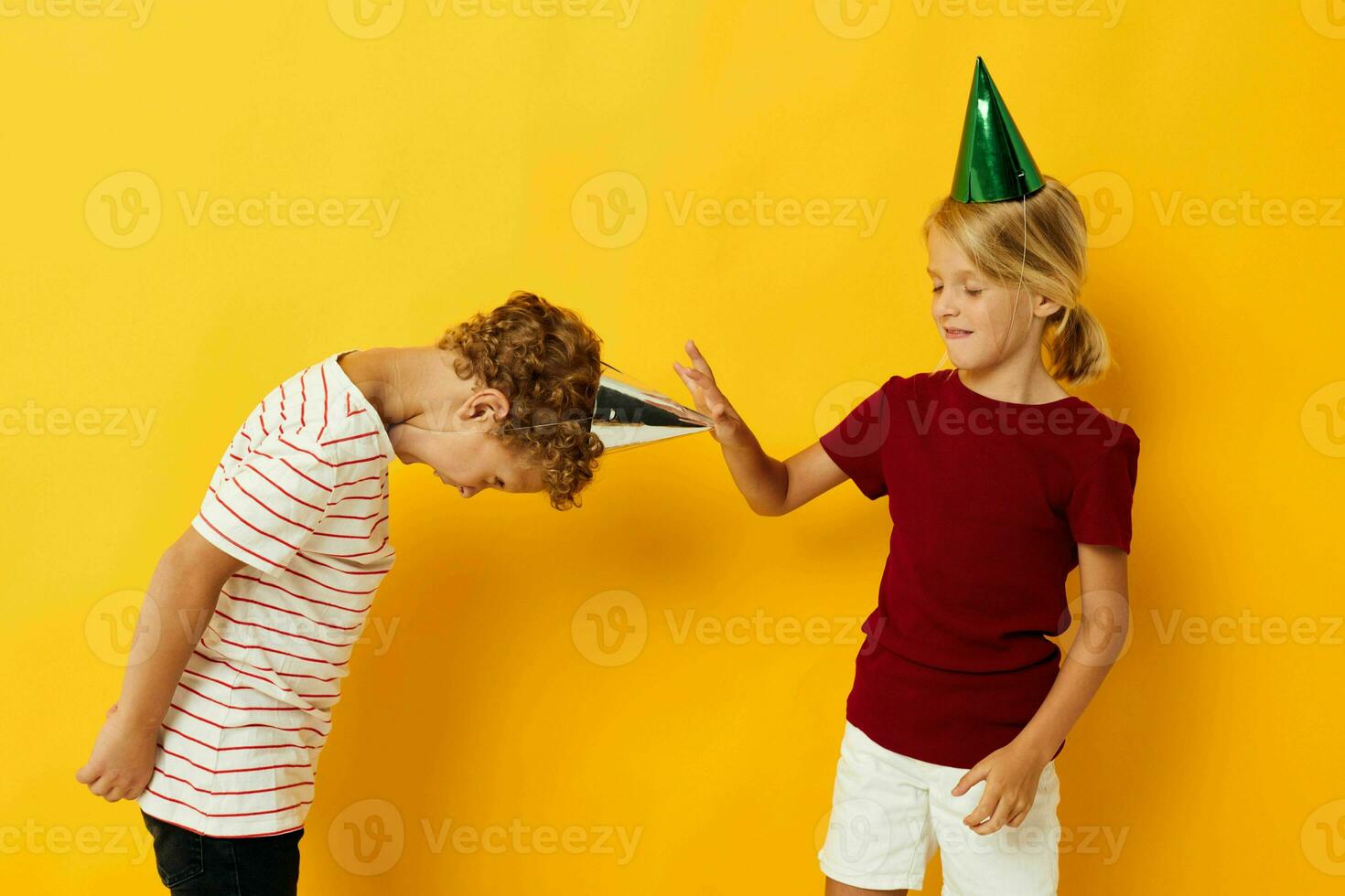 picture of positive boy and girl holiday fun with caps on your head isolated background photo