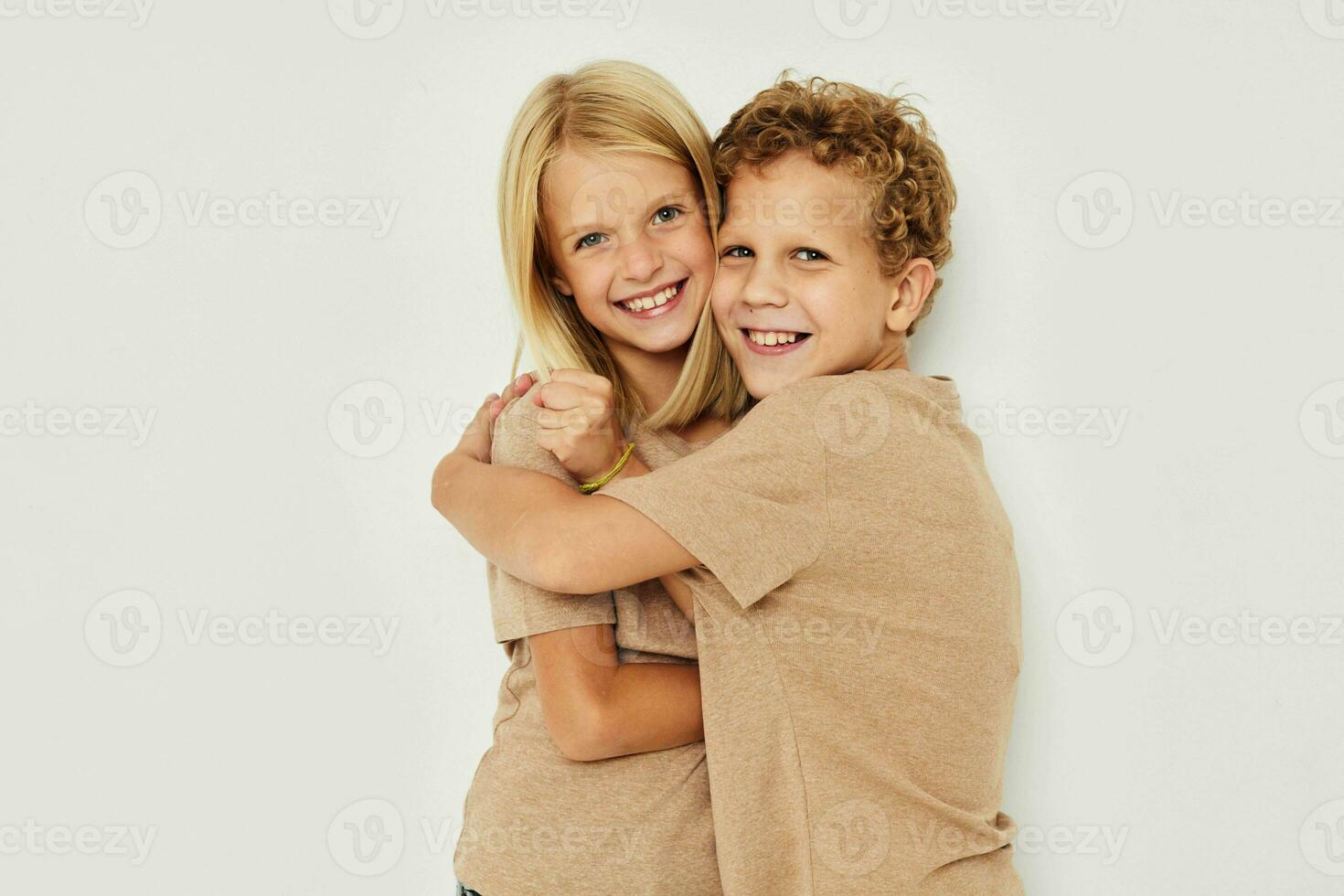 Little boy and girl gesticulate with their hands together light background photo