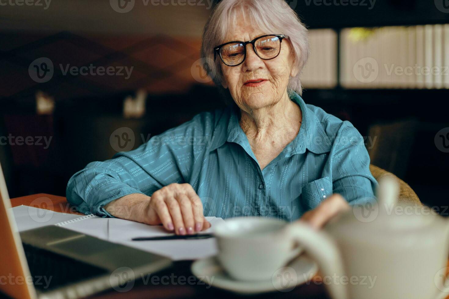 elderly woman working in front of laptop monitor sitting Retired woman chatting unaltered photo