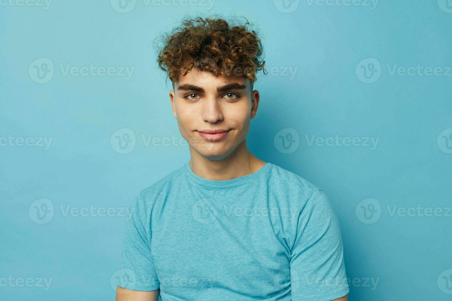 Attractive man in blue t-shirts with a pumped-up body blue background photo