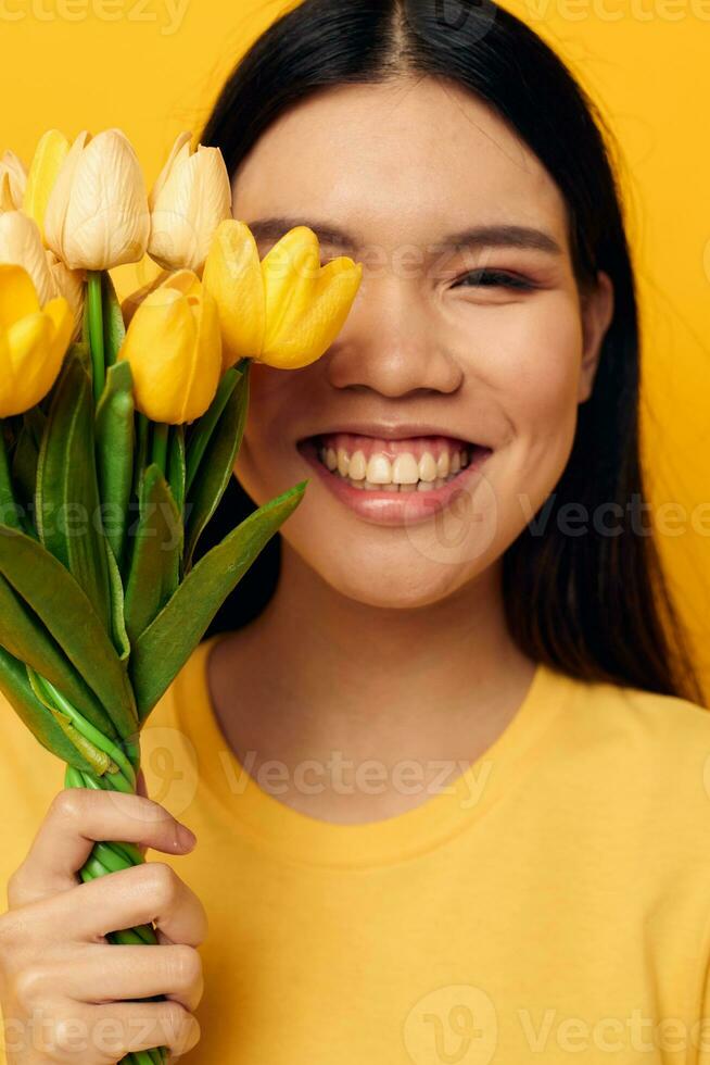 encantador joven asiático mujer con un ramo de flores de amarillo flores romance estudio modelo inalterado foto