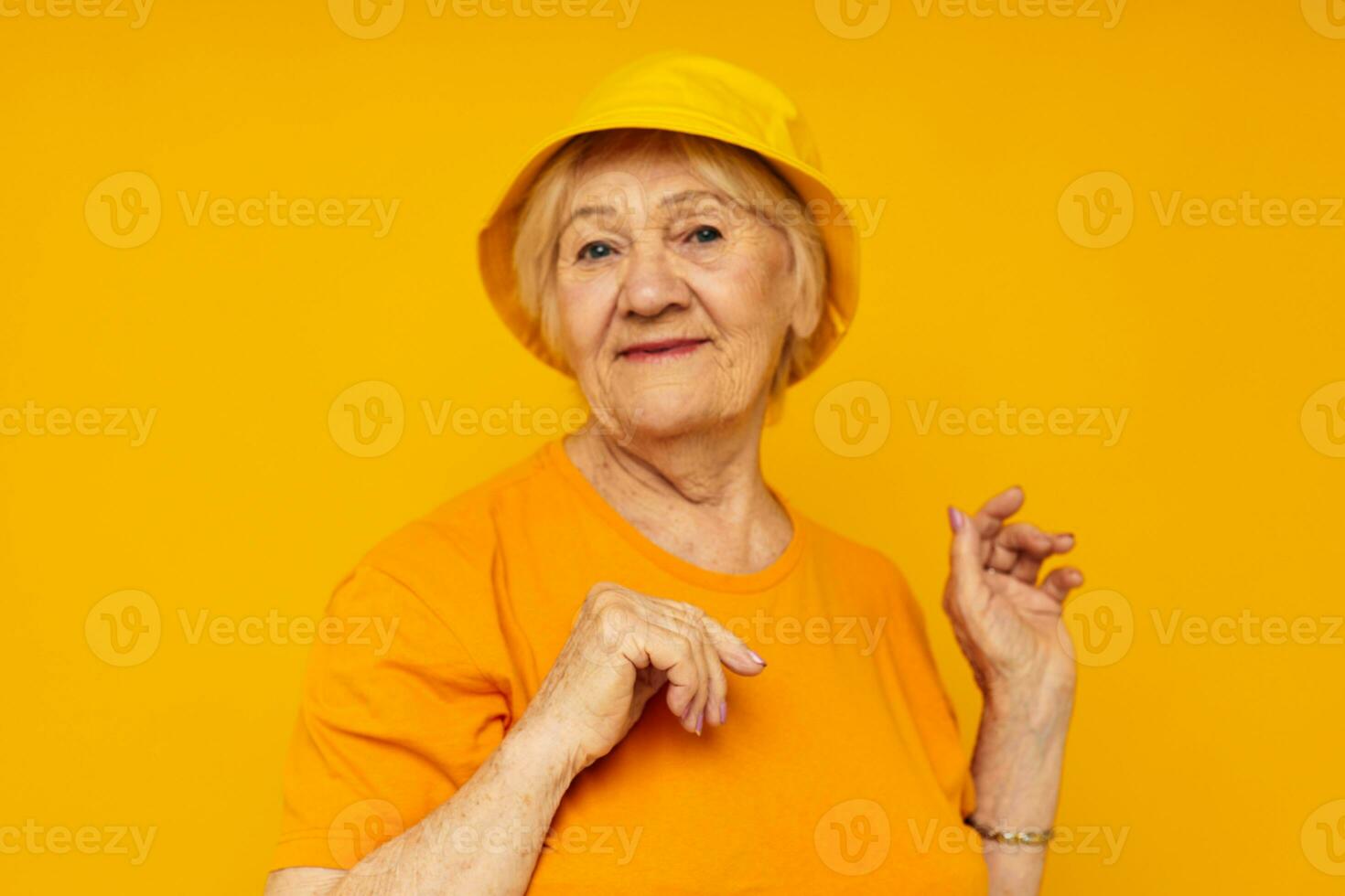 elderly woman happy lifestyle in a yellow headdress yellow background photo