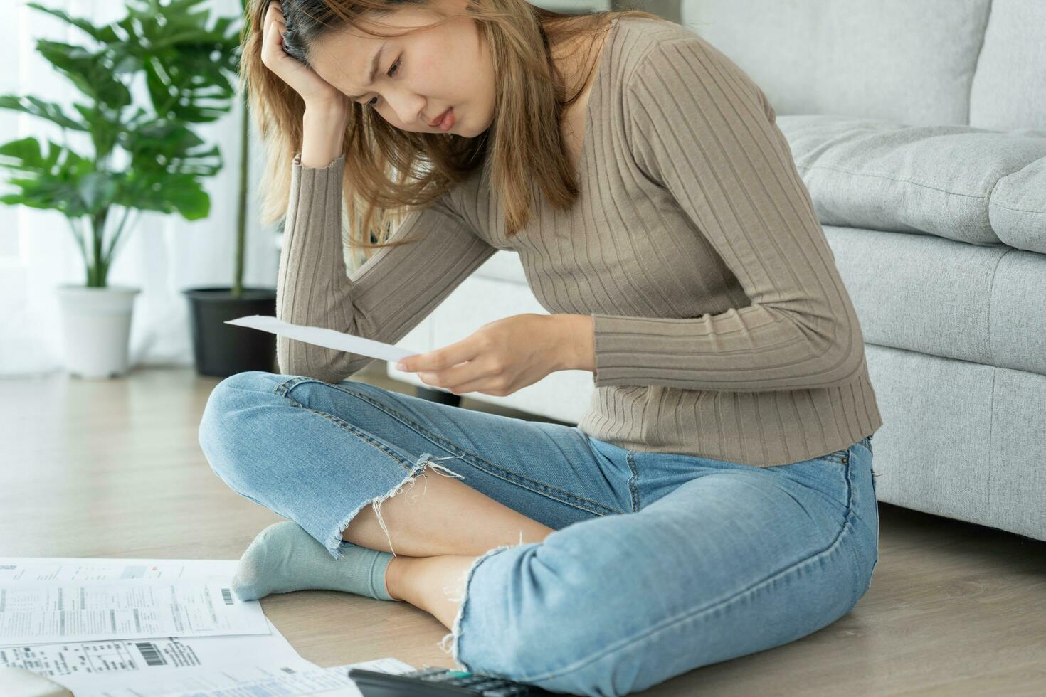 Stressed and headache asian woman with large bills or invoices no money to pay to expenses and credit card debt. shortage, Financial problems, mortgage, loan, bankruptcy, bankrupt, poor, empty wallet photo