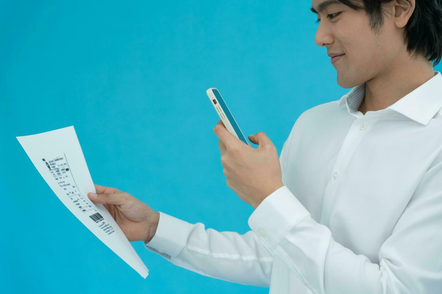 business man use phone to scan barcode or QR codes to pay credit card bill after receiving document invoice online. payment, receive, paying electricity, digital payments without money, technology photo