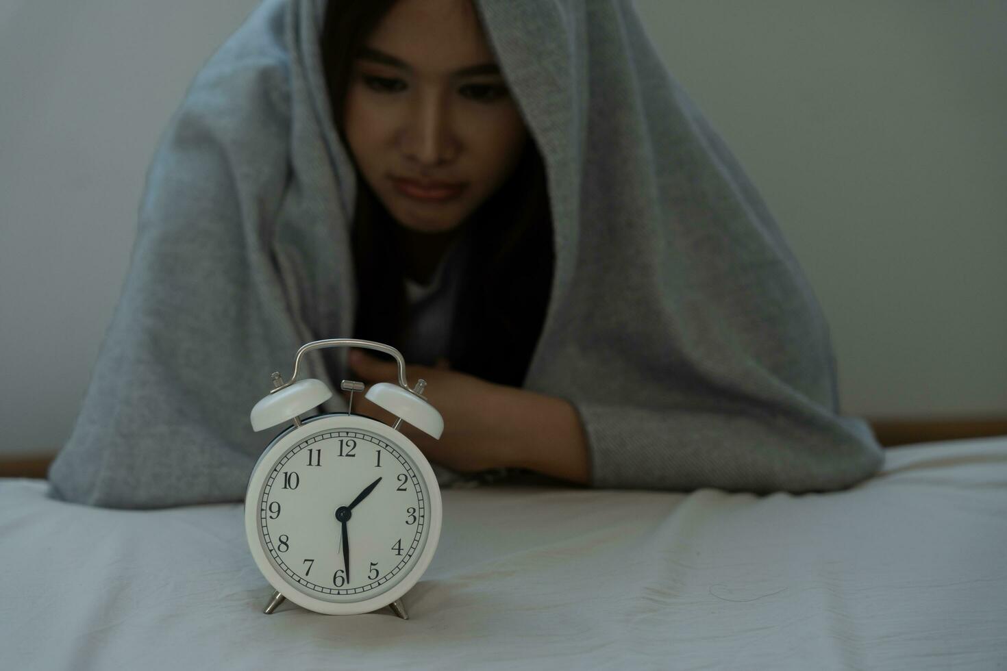 asiático mujer en cama tarde molesto a dormir sufrimiento insomnio, insomne o asustado en un pesadilla, mirando triste preocupado y estresado. cansado y dolor de cabeza o migraña despertar arriba en el medio de el noche. foto