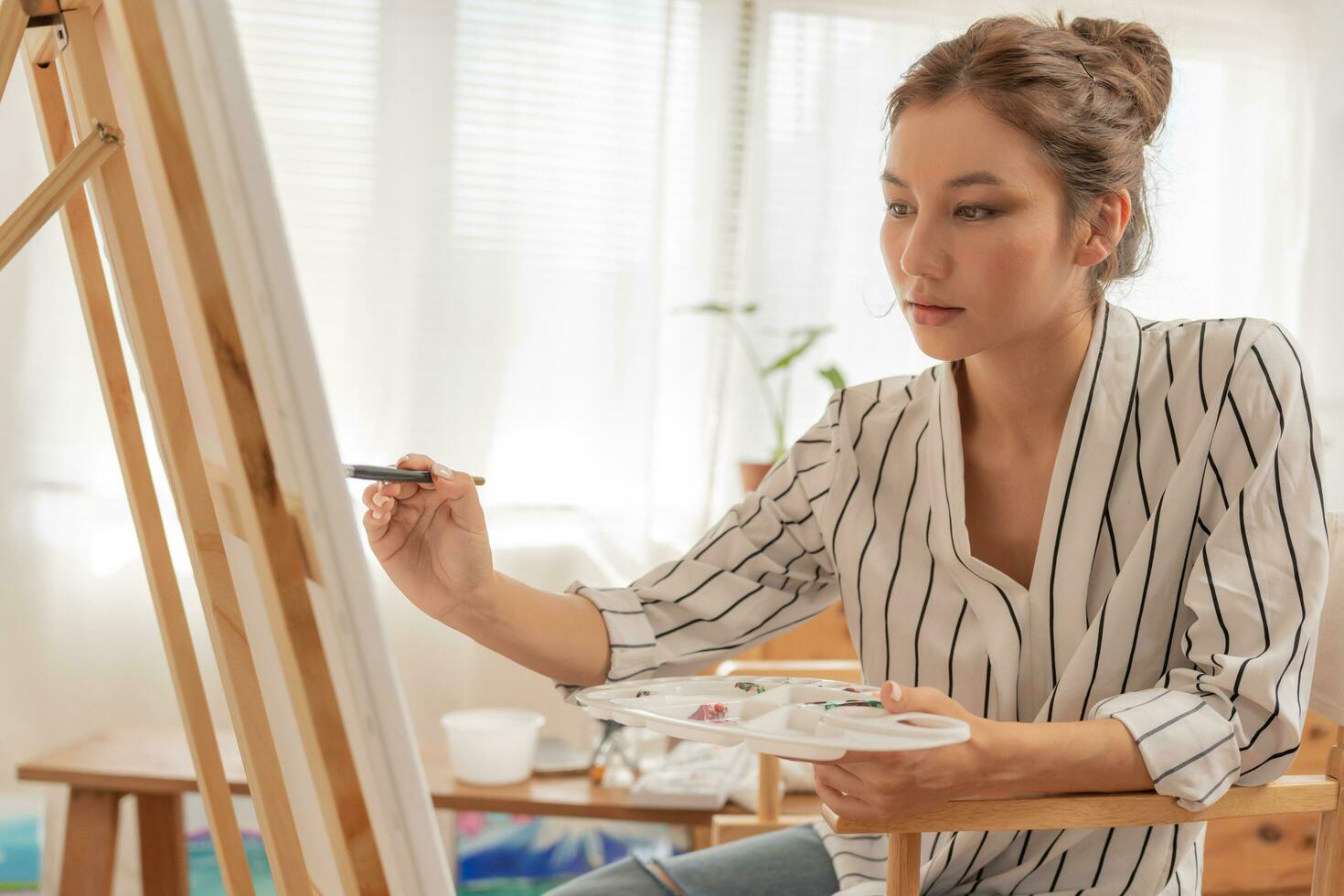 Professional female artist girl use paintbrush in abstract art for create masterpiece. painter paint with watercolors or oil in studio house. beautiful woman enjoy painting as hobby. work recreation photo