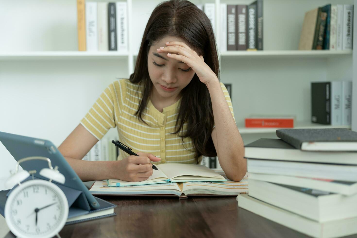 Asian student woman have anxiety because of exams, female prepare for test and learning lessons in the library. stress, despair, haste, misunderstanding reading, discouraged, expectation, knowledge photo