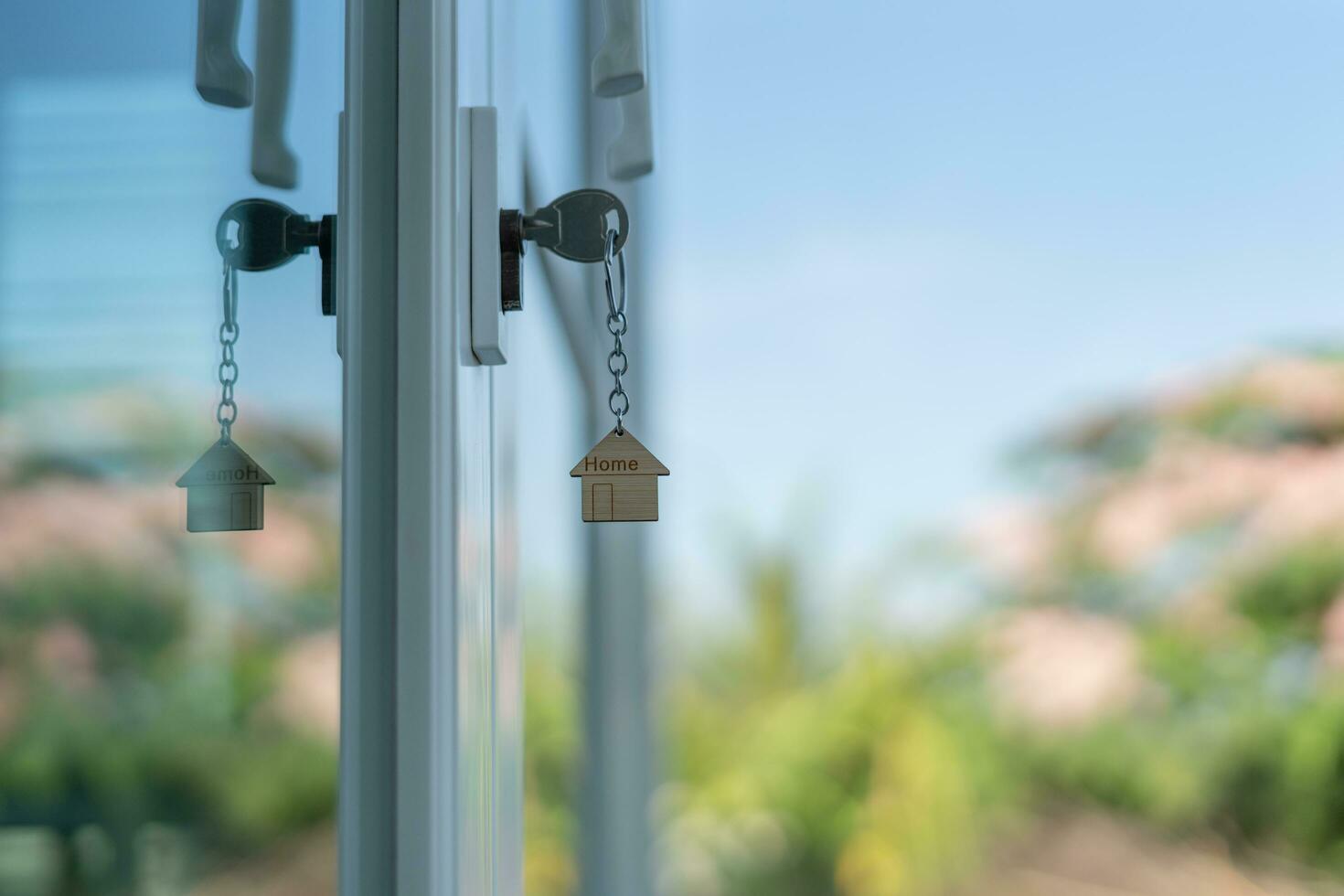 Landlord key for unlocking house is plugged into the door. Second hand house for rent and sale. keychain is blowing in the wind. mortgage for new home, buy, sell, renovate, investment, owner, estate photo
