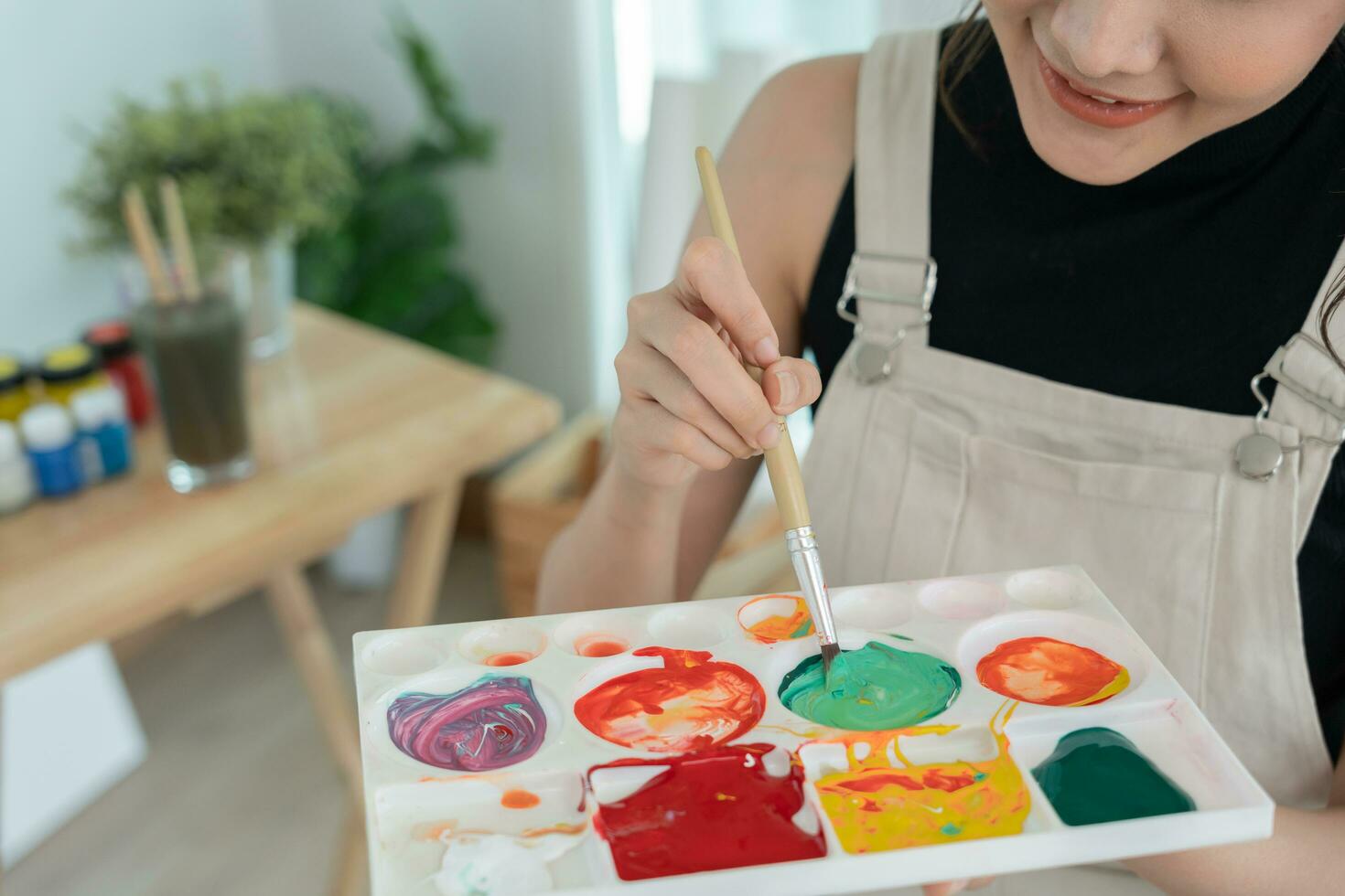 Professional female artist girl use paintbrush in abstract art for create masterpiece. painter paint with watercolors or oil in studio house. beautiful woman enjoy painting as hobby. work recreation photo