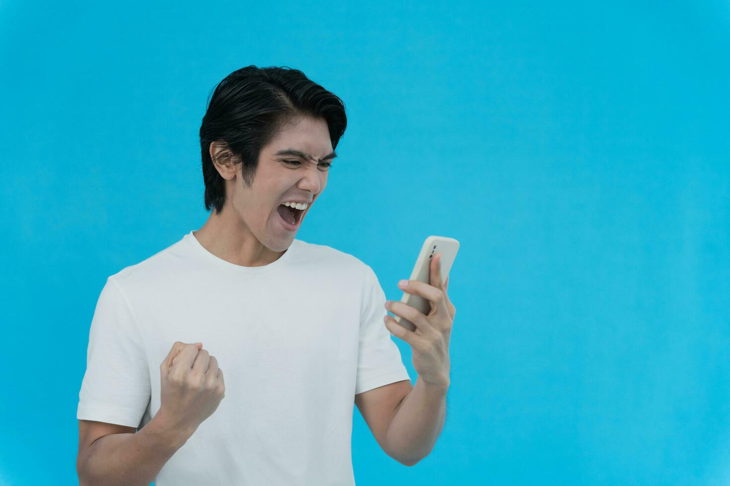 Asian handsome man exited surprise face expression . Male feels shocked with the phone. exciting smile and happy adorable rejoices. Very enjoy and fun relax time. wow, girl holding smartphone. photo