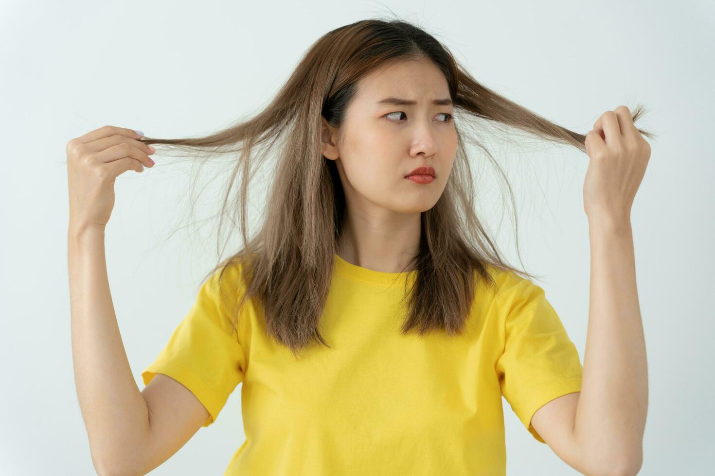 Asian woman very sad and upset looking at damaged hair, hair loss, hair thinning problem, vitamin deficiency, baldness, postpartum, biotin, zinc, menstrual or endocrine disorders, hormonal imbalance photo