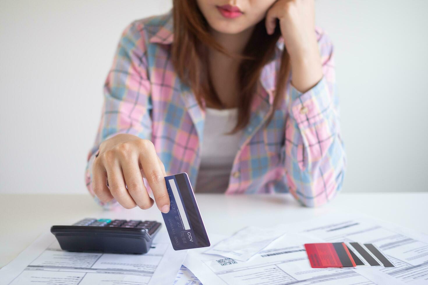 Stressed and headache asian woman with large bills or invoices no money to pay to expenses and credit card debt. shortage, Financial problems, mortgage, loan, bankruptcy, bankrupt, poor, empty wallet photo