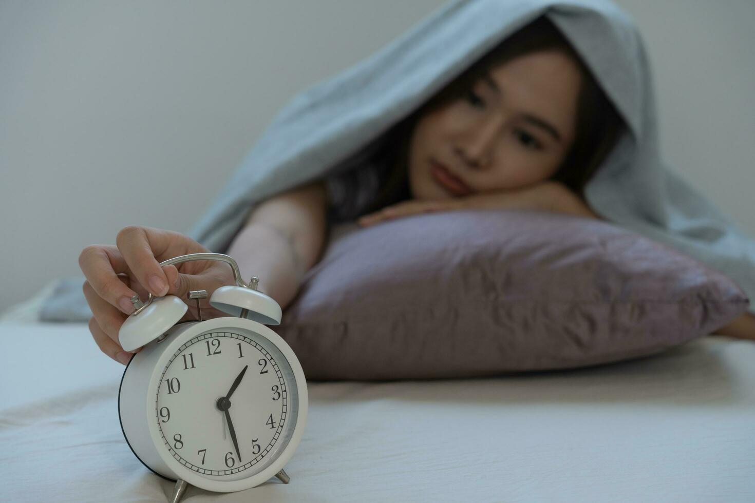 asiático mujer en cama tarde molesto a dormir sufrimiento insomnio, insomne o asustado en un pesadilla, mirando triste preocupado y estresado. cansado y dolor de cabeza o migraña despertar arriba en el medio de el noche. foto