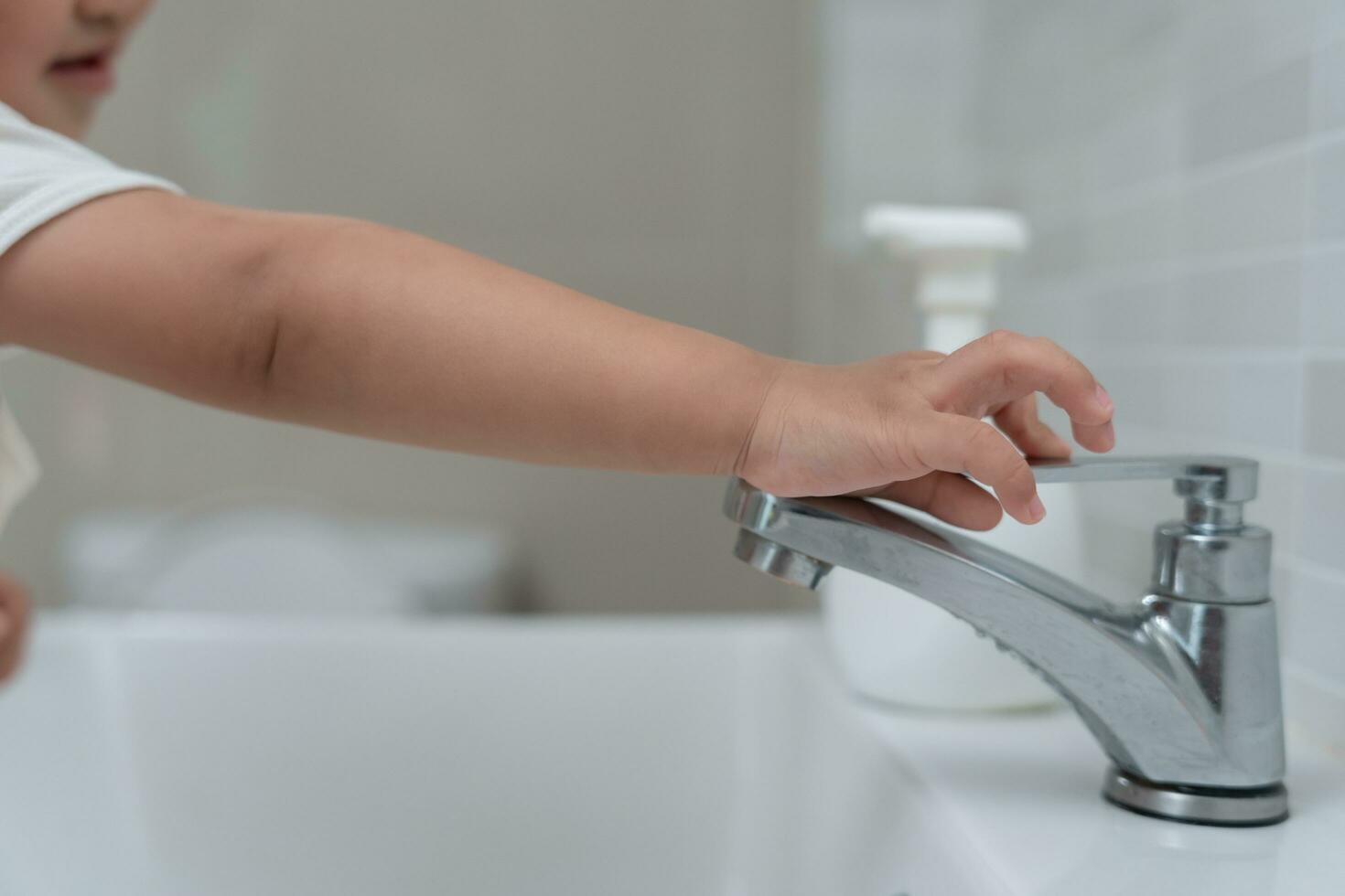 Save water. Little kid keeps turning off the running water in the bathroom to protect environment. Greening planet, reduce global warming, Save world, life, future, risk energy, crisis , water day. photo