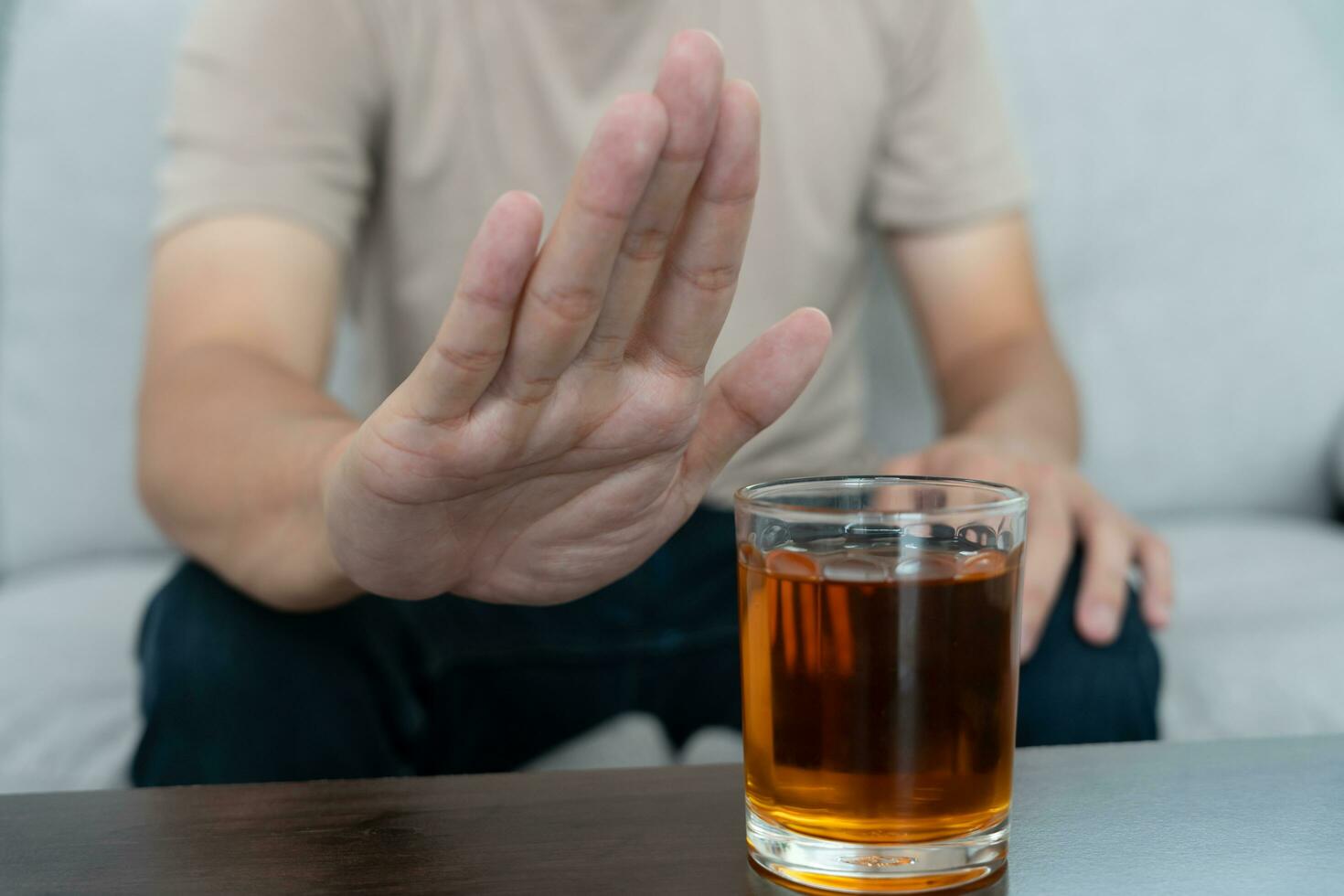 man refuses say no and avoid to drink an alcohol whiskey , stopping hand sign male, alcoholism treatment, alcohol addiction, quit booze, Stop Drinking Alcohol. Refuse Glass liquor, unhealthy, reject photo