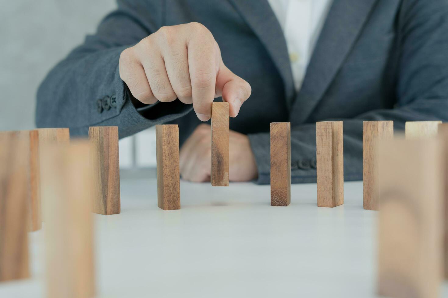 insurance with hands protect domino. Businessman hands stop dominoes falling in business crisis. business risk control and planning and strategies to run prevent insurance businesses. photo