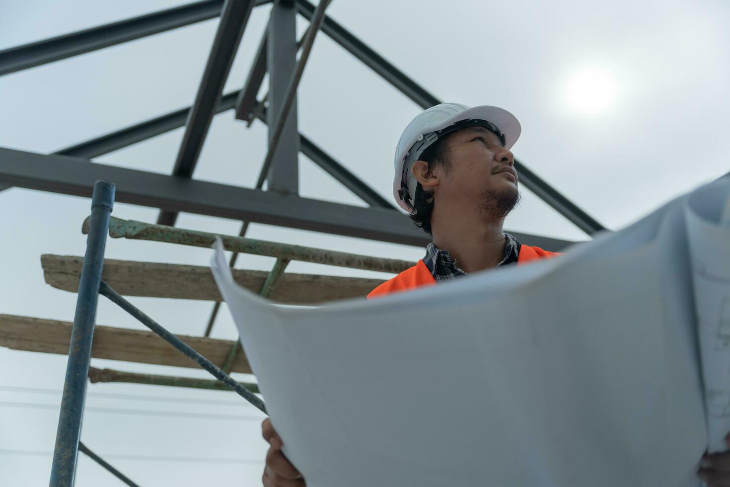 Engineers or inspector holding blueprint of construction on site. Contractor inspection drawing before start project civil. Prepare construction project planning, consulting, architecture. photo