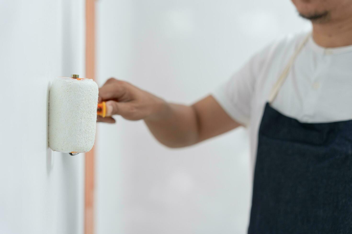 painter man, brush in hand for products to restore and paint the wall, indoor the building site of a house, wall during painting, renovation, painting, contractor, Architect, construction worker photo