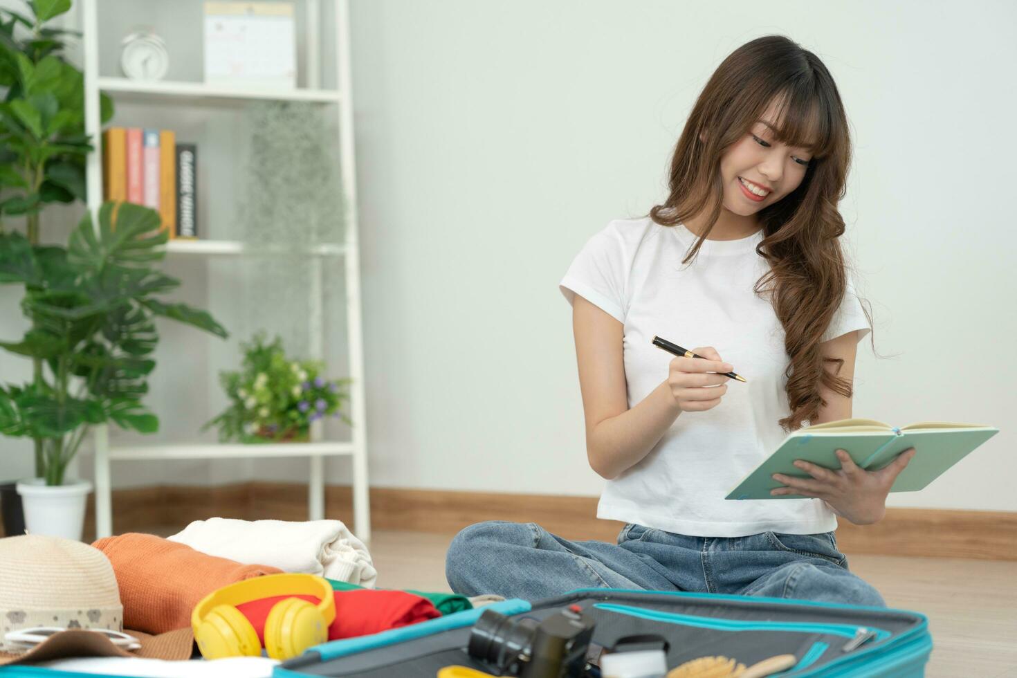 Travel bag. female are checking the detail and quantity of items used during the trip by checklist. Young women are prepare clothes and personal belongings. Pack your luggage before travel. photo