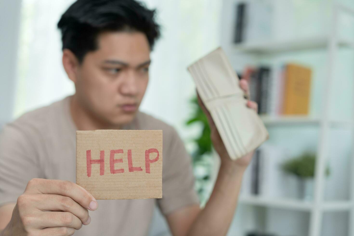 Stressed and headache asian man with large bills or invoices no money to pay to expenses and credit card debt. shortage, Financial problems, mortgage, loan, bankruptcy, bankrupt, poor, empty wallet photo