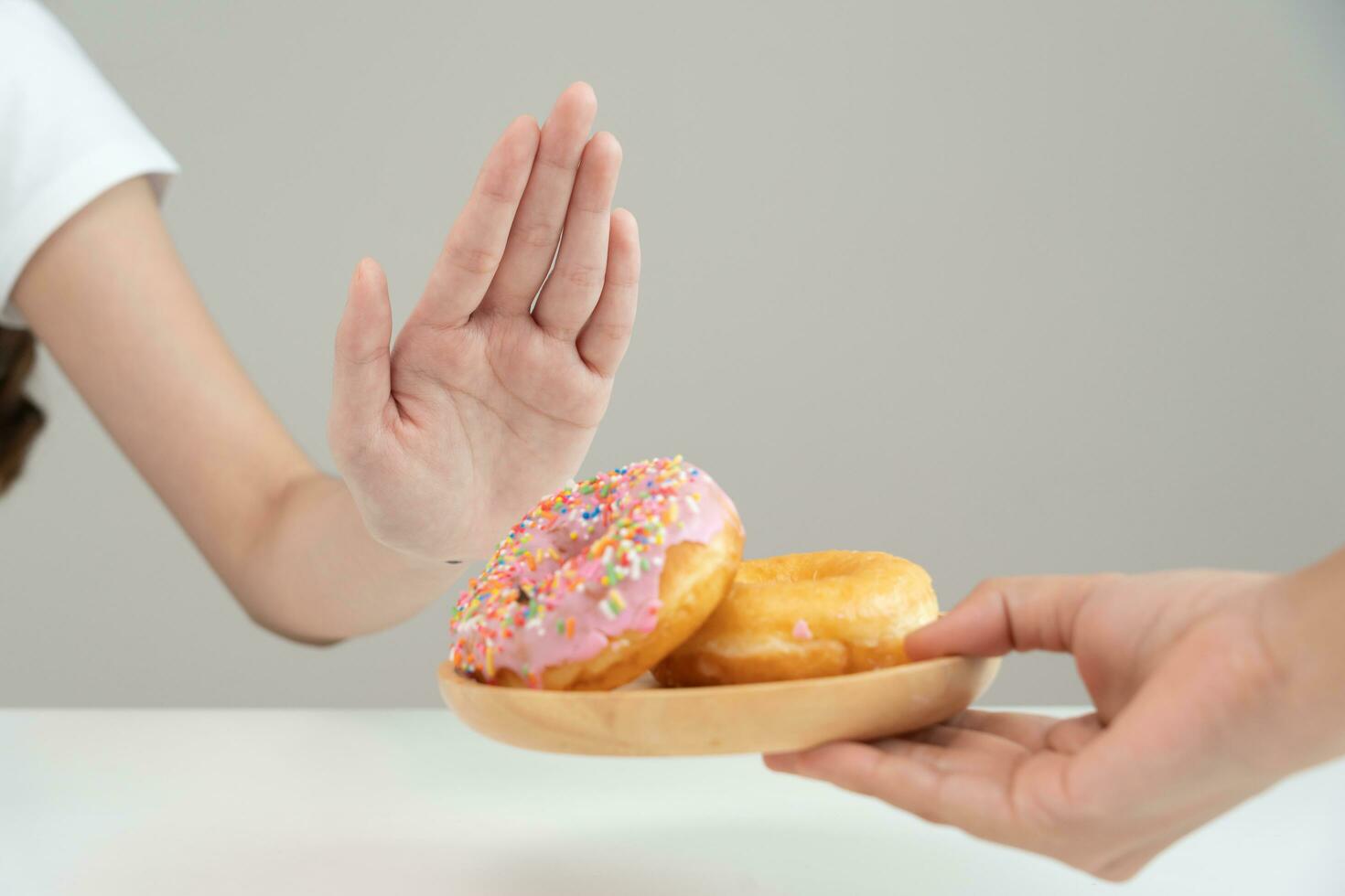 Diet and dieting. Beauty slim female body confuse donut. Woman in exercise clothes achieves weight loss goal for healthy life, crazy about thinness, thin waist, nutritionist. photo