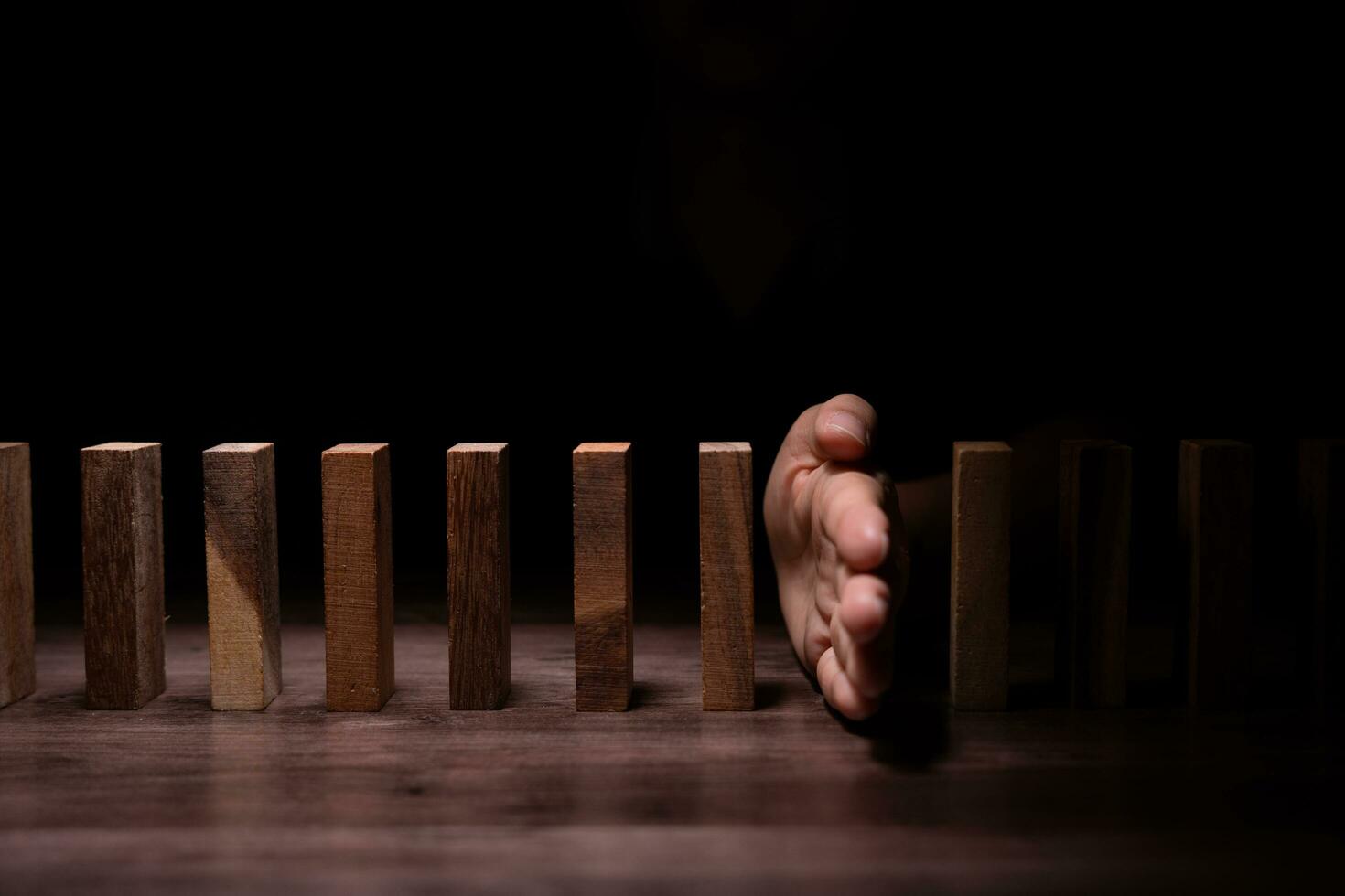 insurance with hands protect domino. Businessman hands stop dominoes falling in business crisis. business risk control and planning and strategies to run prevent insurance businesses. photo