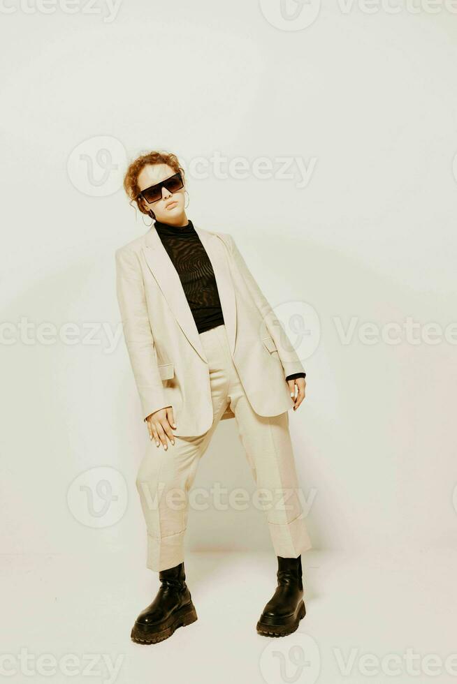 cheerful woman in a suit sunglasses gestures with his hands emotions isolated backgrounds unaltered photo