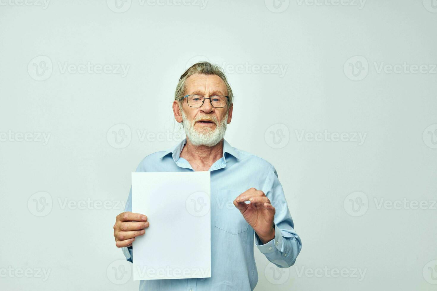 elderly man holding a sheet of paper copy-space posing isolated background photo