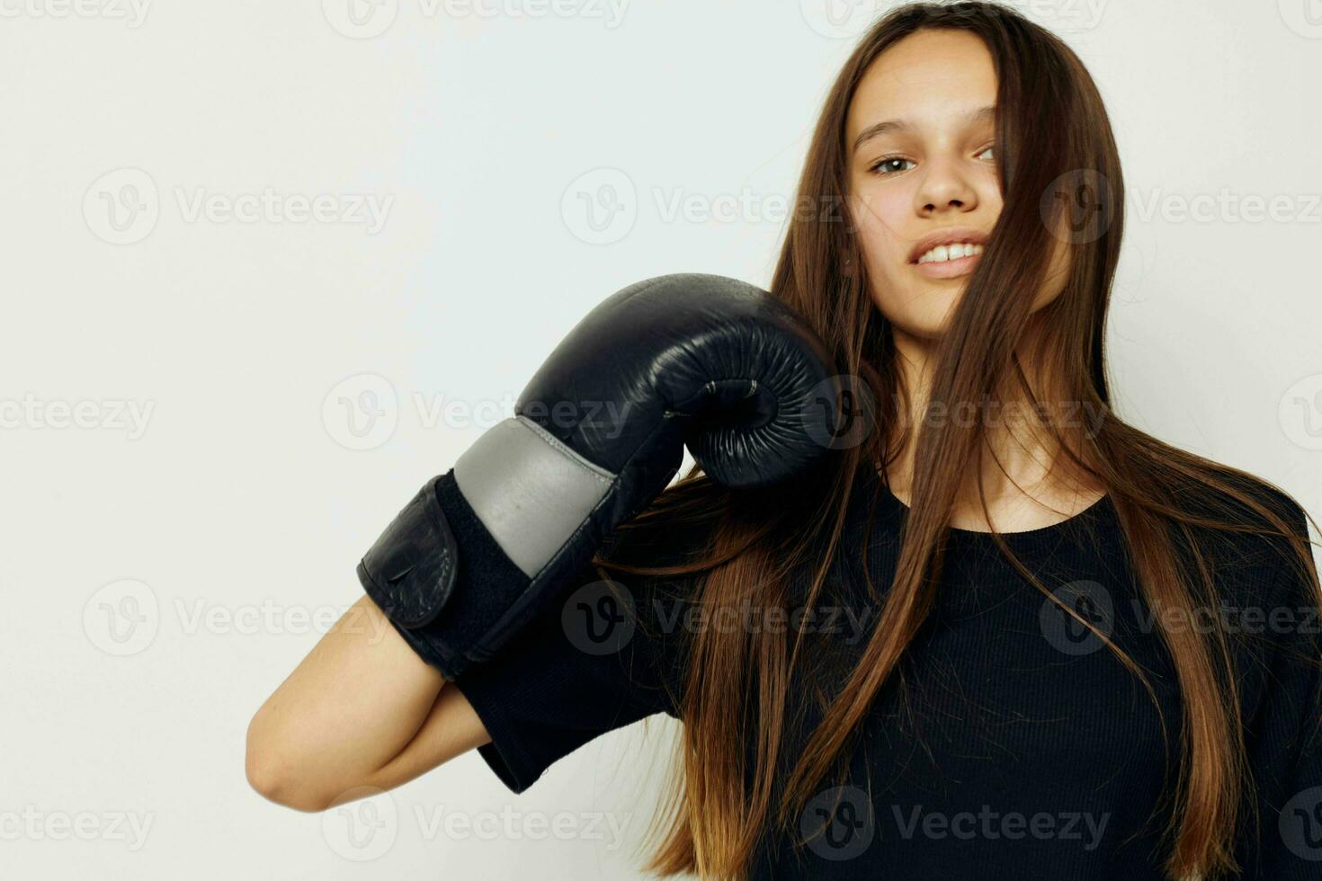 young beautiful woman in black sports uniform boxing gloves posing isolated background photo