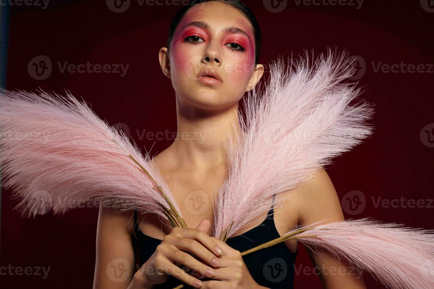 pretty woman with a comb bright makeup posing fluffy feathers isolated background unaltered photo
