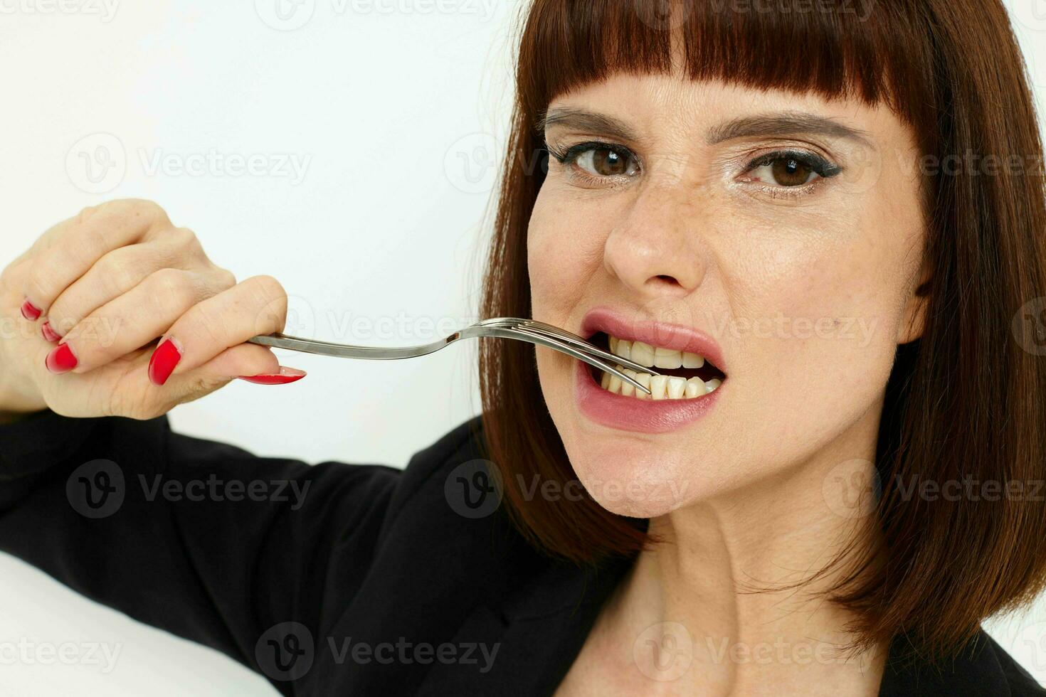 retrato de un mujer en un negro chaqueta un cuchillo y un tenedor cerca el cara estilo de vida inalterado foto