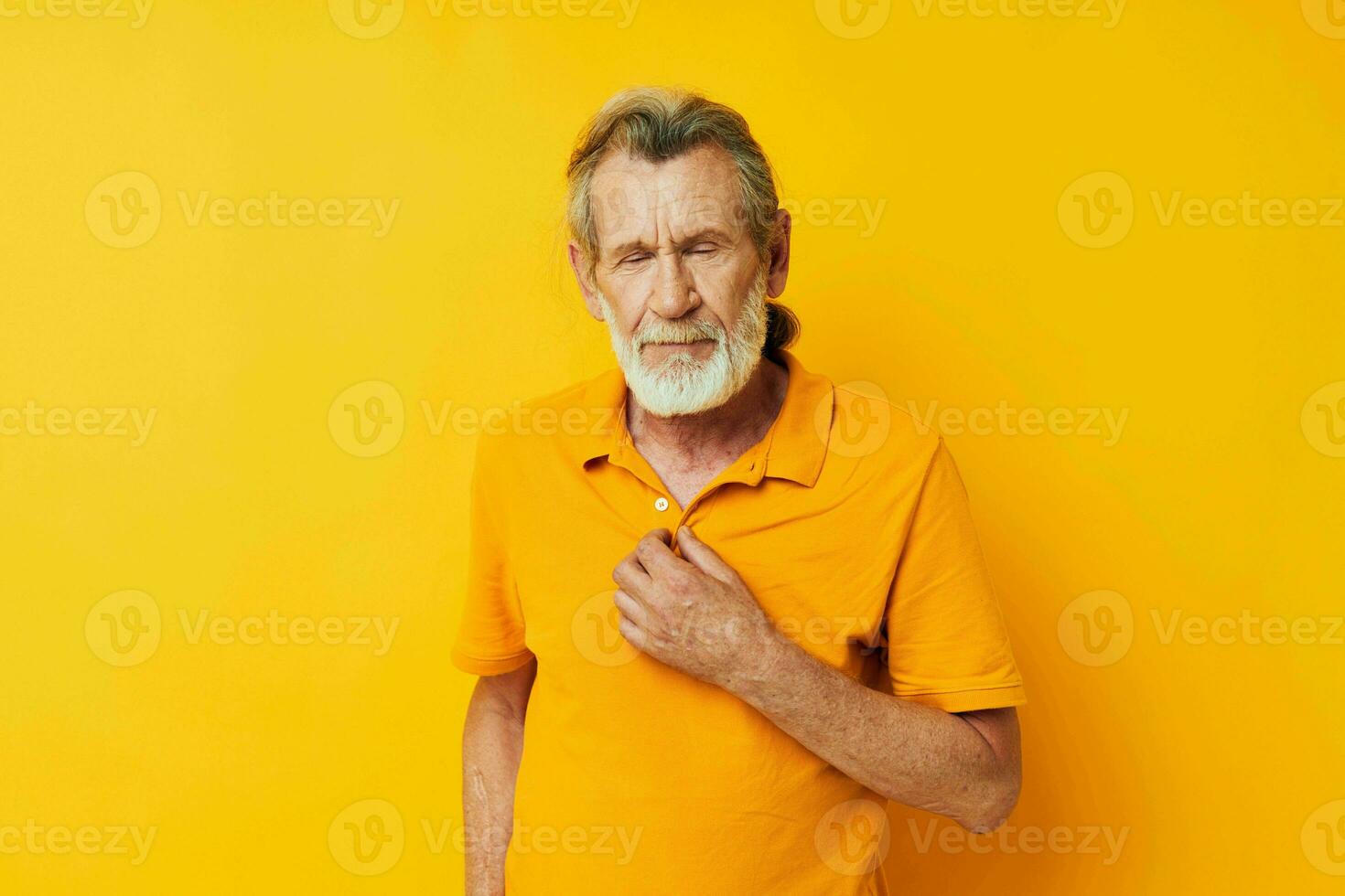 Portrait of happy senior man hand gesture gray beard fun yellow background photo
