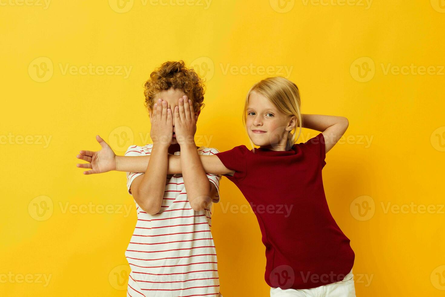 Boy and girl casual wear games fun together yellow background photo