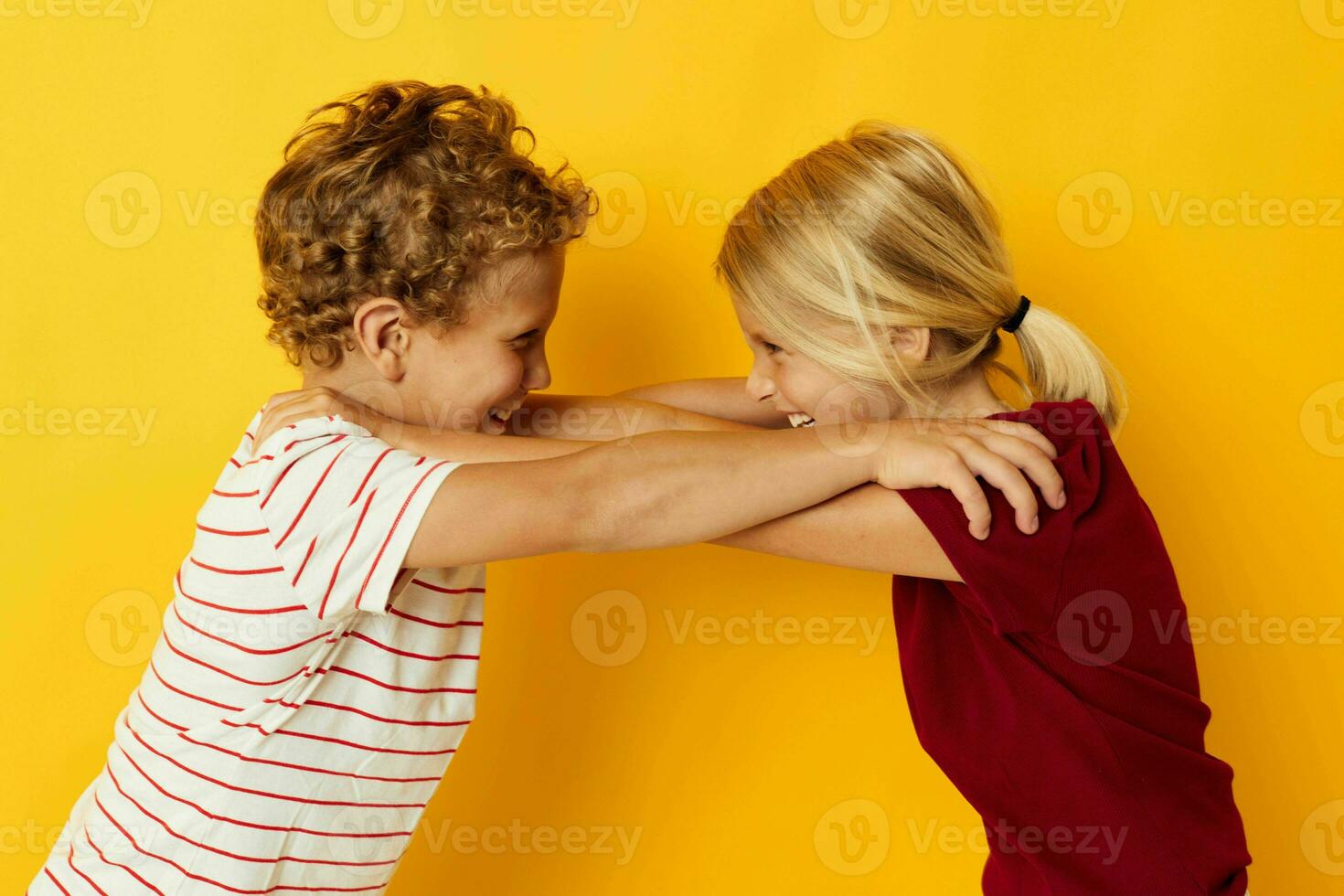 two joyful children standing side by side posing childhood emotions on colored background photo