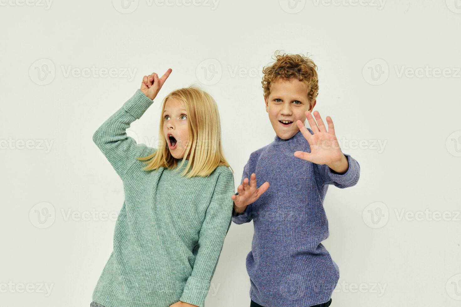 Boy and girl in multi-colored sweaters posing for fun Lifestyle unaltered photo