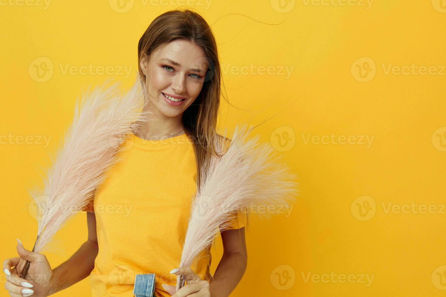 atractivo mujer en amarillo camisetas, rosado plumas aislado antecedentes foto