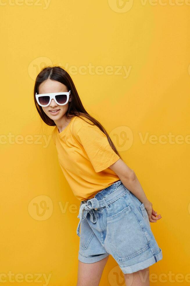 optimistic young woman hand gesture emotions summer style yellow background photo