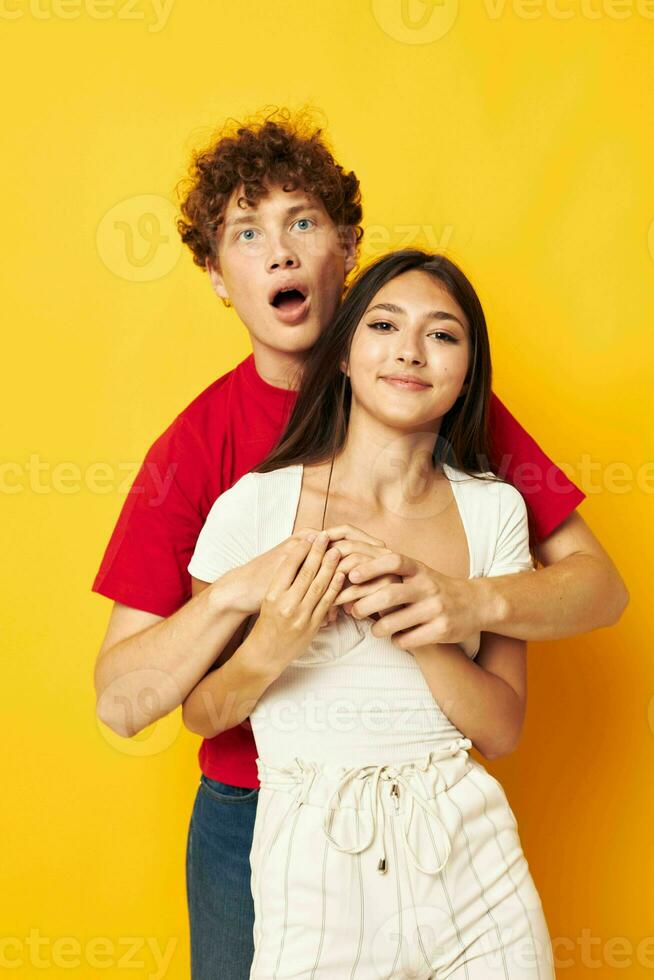 young boy and girl Friendship posing hugs together yellow background unaltered photo