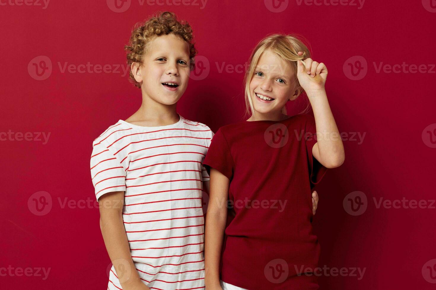 two joyful children emotions stand side by side in everyday clothes isolated background photo