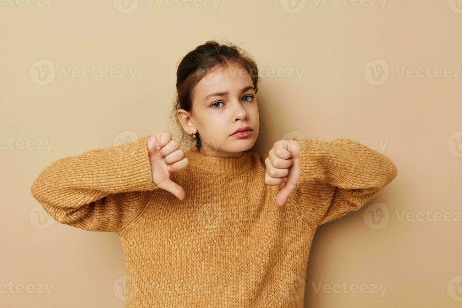 Portrait of happy smiling child girl in sweater posing hand gestures childhood unaltered photo