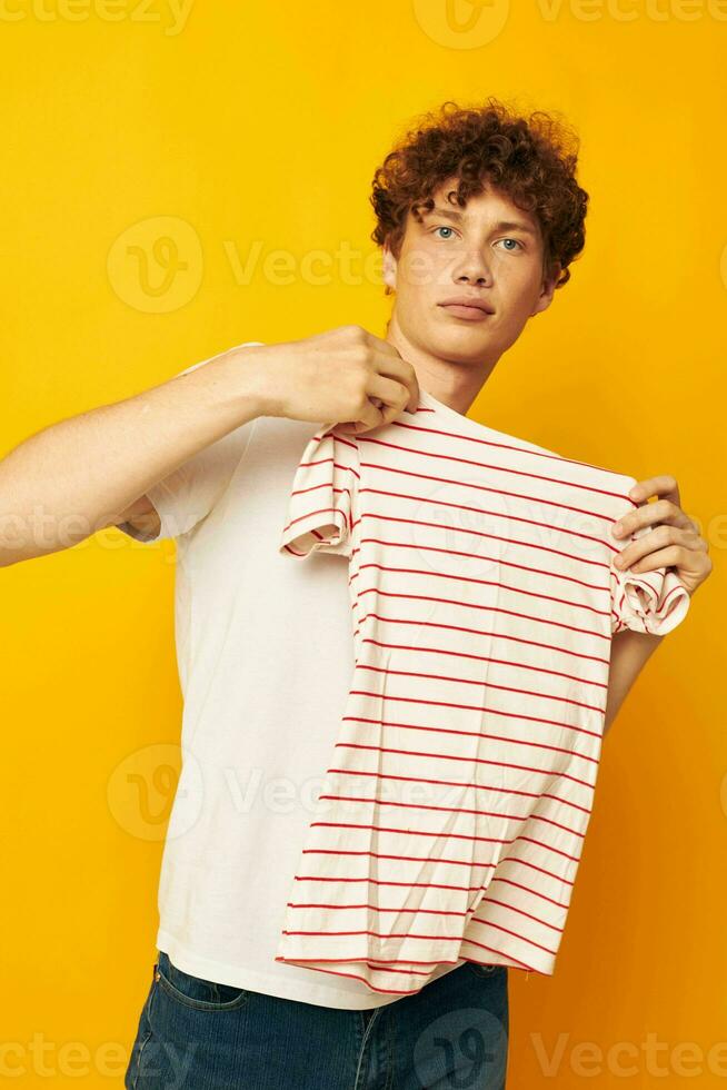 Young curly-haired man striped t shirt posing summer clothing yellow  background unaltered 25027696 Stock Photo at Vecteezy