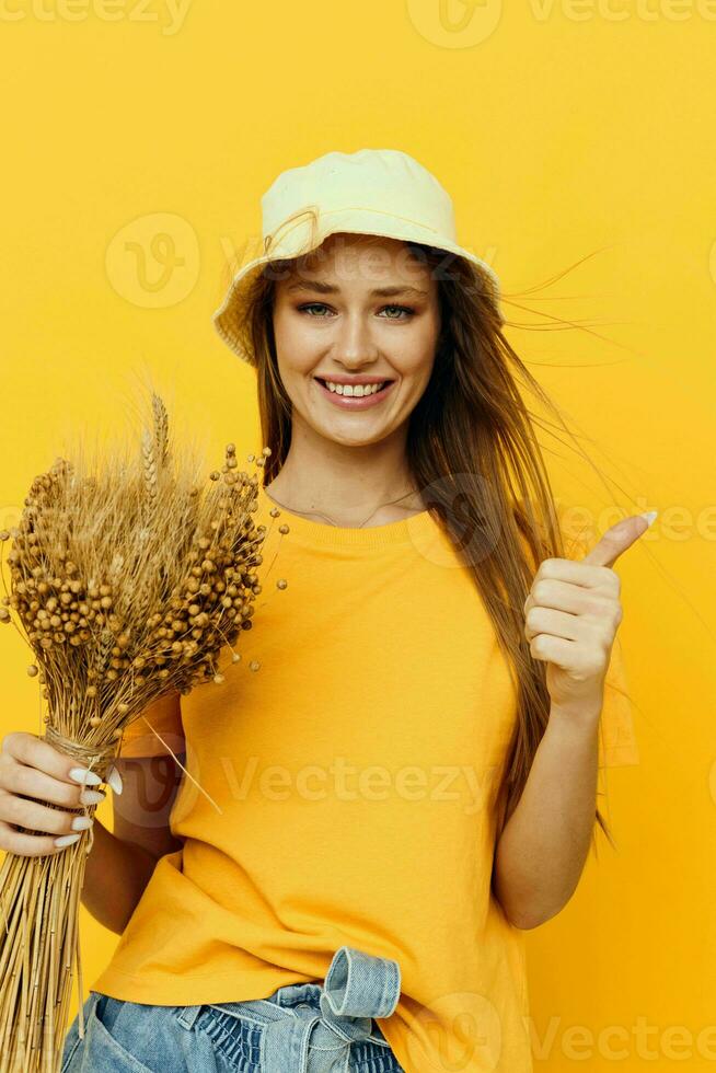 Young woman in yellow T-shirts, dried flowers in hands isolated background photo