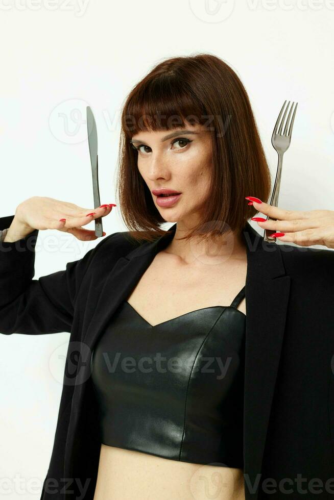 portrait of a woman in a black jacket a knife and a fork near the face