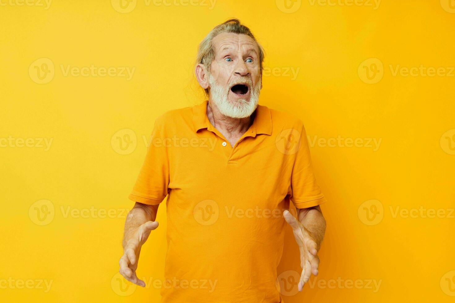 Portrait of happy senior man yellow shirt posing emotions yellow background photo