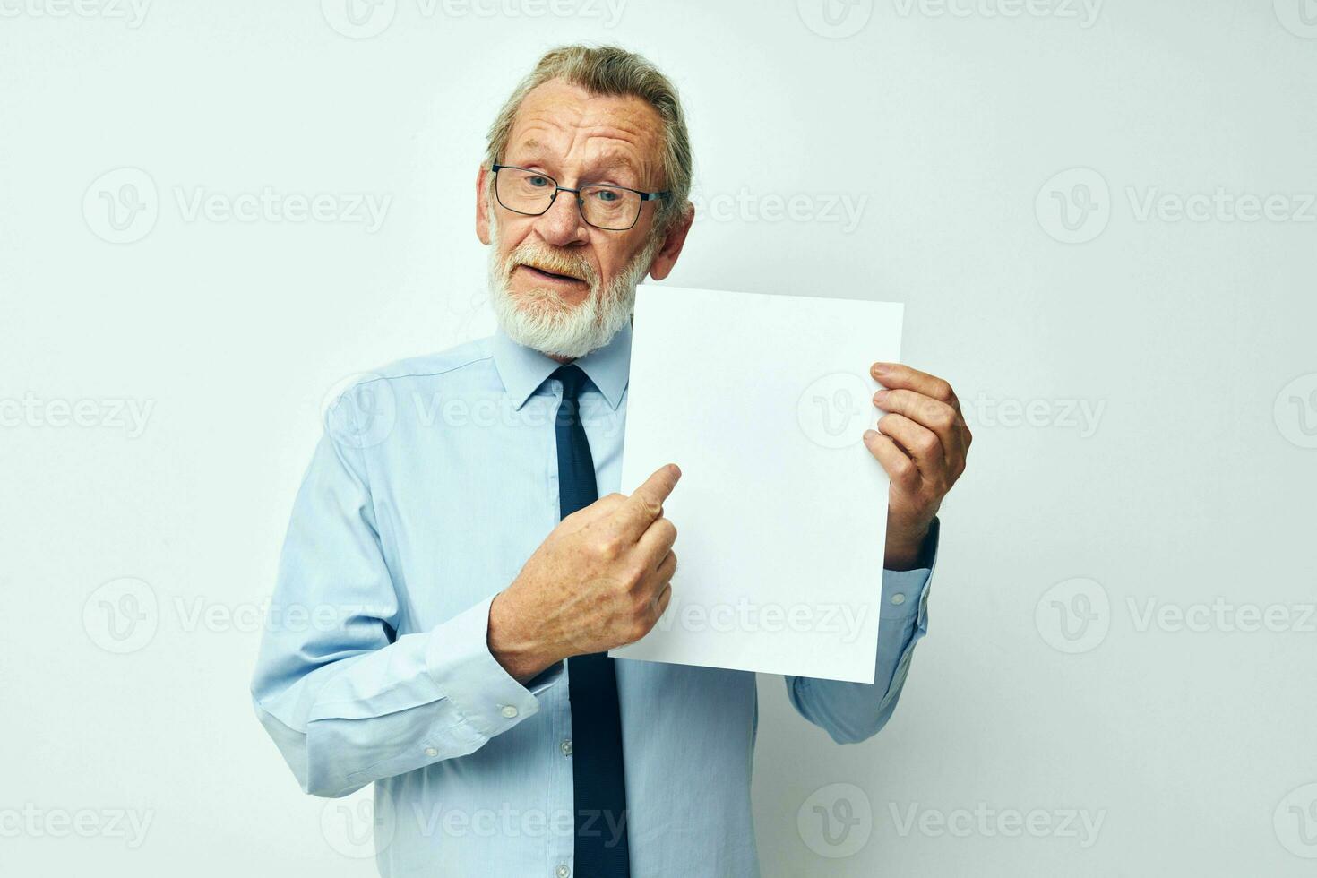 Portrait of happy senior man in a shirt with a tie copy-space sheet of paper cropped view photo