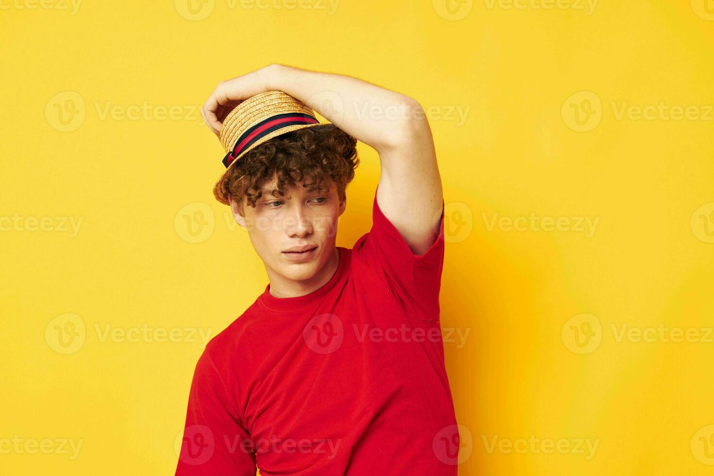 Young curly-haired man in a red t-shirt with a fashion hat Lifestyle unaltered photo