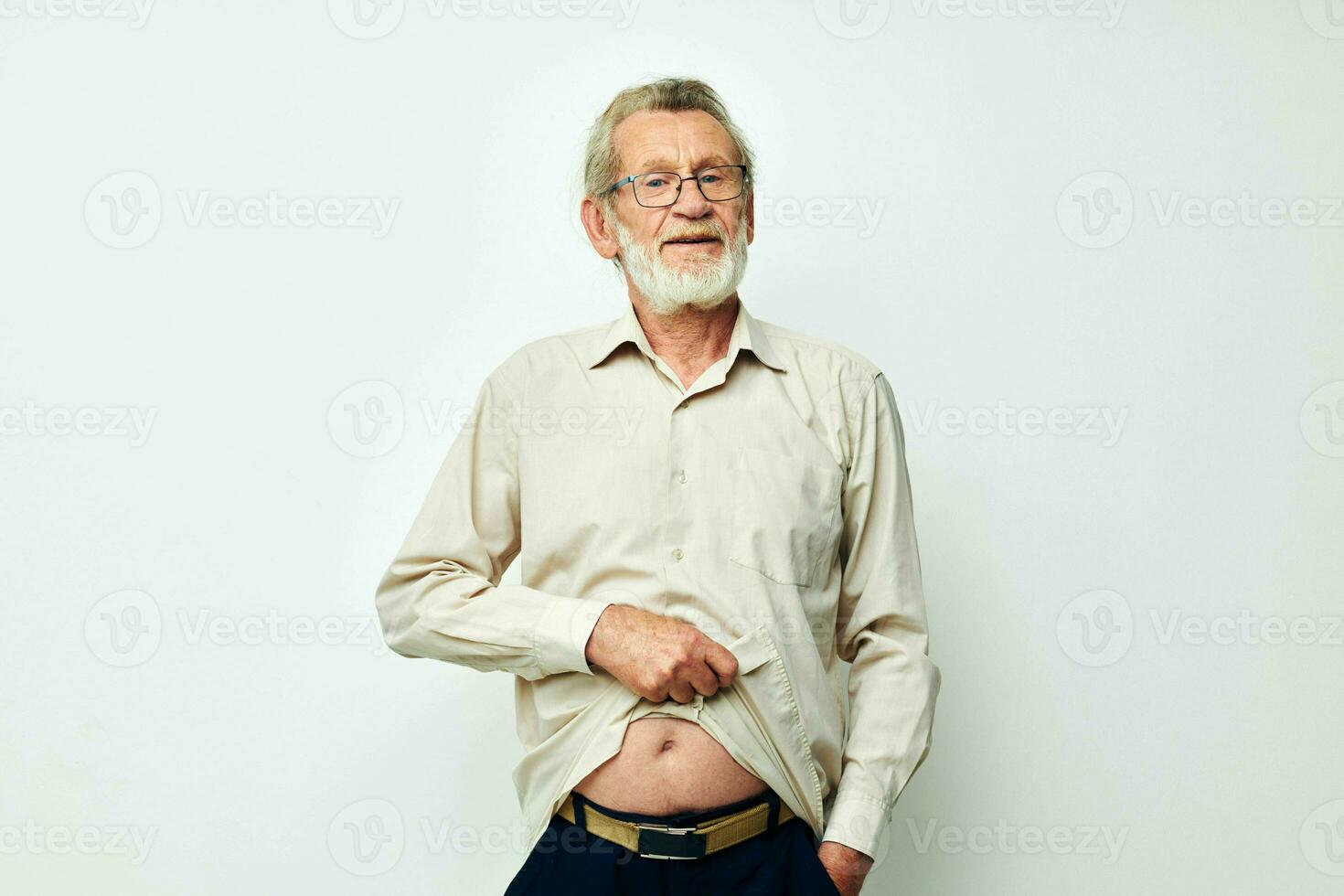 Elderly man posing in studio on gray background and smiling photo